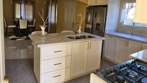 A kitchen with a central island, a refrigerator, and a stove. - 2-bedroom house in wonderful Golden Grove with air conditioning (Golden Grove)