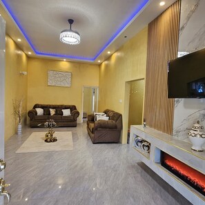 A modern living room with a fireplace, two sofas, a coffee table, and a television. - 2-bedroom house in wonderful Golden Grove with air conditioning (Golden Grove)