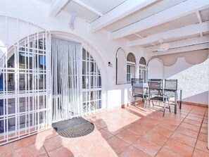 A spacious room with large windows, a tiled floor, and a seating area with chairs and a table. - Oasis 10 by Interhome (El Carmoli)