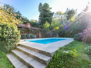 A swimming pool with steps leading up to it, surrounded by greenery and a building with a tiled roof. - Belvedere by Interhome (Gaiole in Chianti)