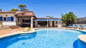 Piscina com terraço solar, área de estar externa e espaço coberto.