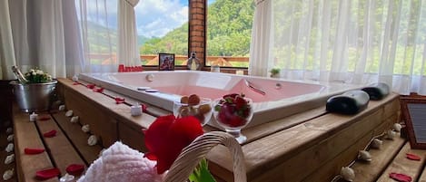A room with a wooden bench, a table with a red 'Amen' sign, and a view of green hills through sheer curtains.