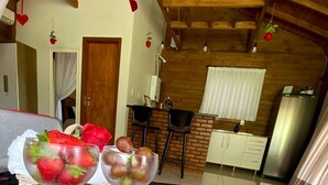 Une table à manger avec une carte en forme de cœur rouge et deux bols de fruits.