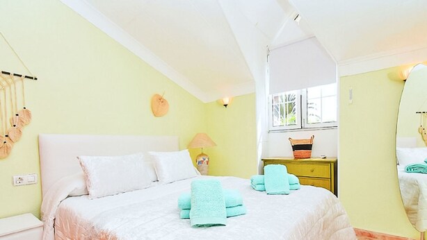 A bedroom with a bed, bedside tables, a lamp, and a window. - Olivos 3 by Interhome (Los Urrutias)