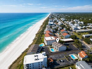 A coastal resort with beachfront properties, a swimming pool, and a parking area. - Seagrove Beachside Retreat: Ocean and Pool Views: Private Beach: Sleeps 11 (Santa Rosa Beach)