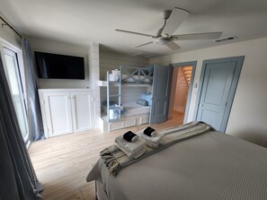 A bedroom with a bed, a ceiling fan, a TV mounted on the wall, and a wardrobe with a built-in shelf. - Seagrove Beachside Retreat: Ocean and Pool Views: Private Beach: Sleeps 11 (Santa Rosa Beach)