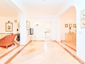 Un'ampia zona giorno con camino, televisore e sala da pranzo con mobile e vaso.