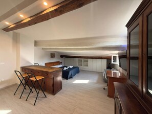 A spacious room with a wooden dining table, a sofa, and a TV. - Il Pittore by Interhome (Pisa)