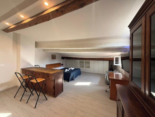 Una habitación amplia con una mesa de comedor de madera, un sofá y una televisión.