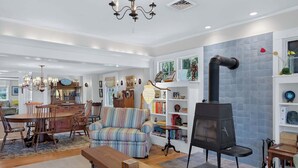 Uma sala de estar aconchegante com lareira, área de jantar e estante de livros.