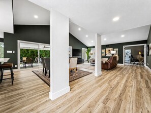 A spacious living area with a high ceiling, wooden flooring, and a view of a green outdoor space. - Sun Lakes Cottonwood! Upgraded, All New! Amenities Galore. 40+ (Chandler)