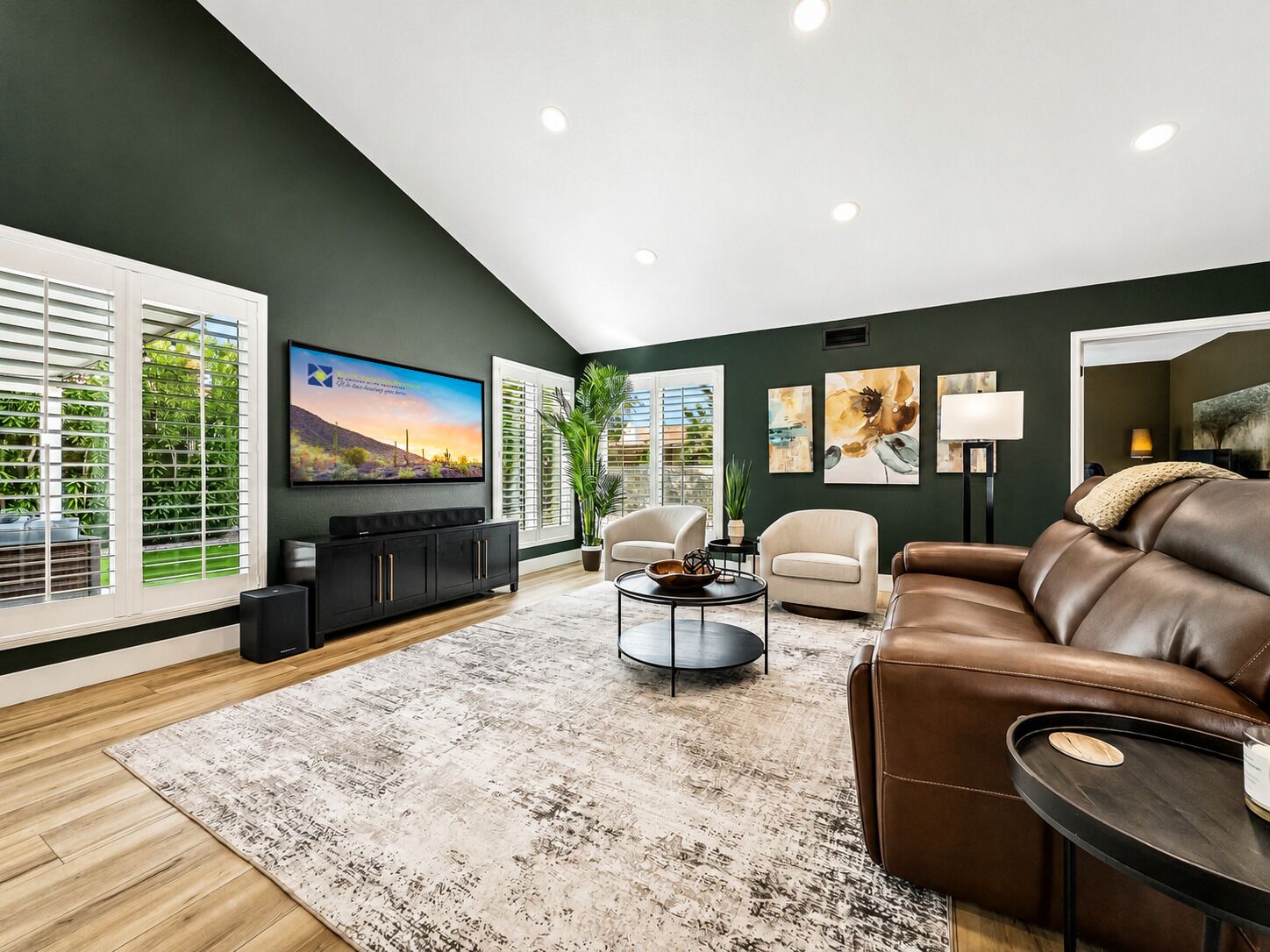 Un salon moderne avec un téléviseur à écran plat, un canapé en cuir et une table basse.