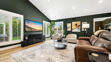 Un salon moderne avec un téléviseur à écran plat, un canapé en cuir et une table basse.
