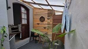 Una habitación pequeña con separador de madera, una mesa y sillas.