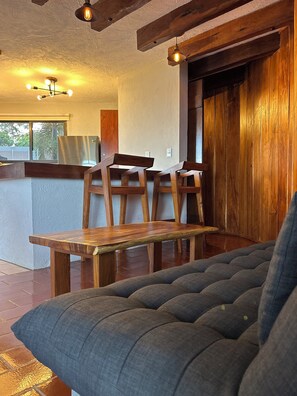 A cozy interior with a wooden dining table, chairs, and a sofa.
