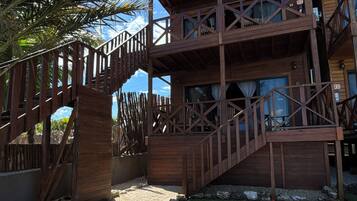A wooden multi-level building with a staircase leading to the upper floor.