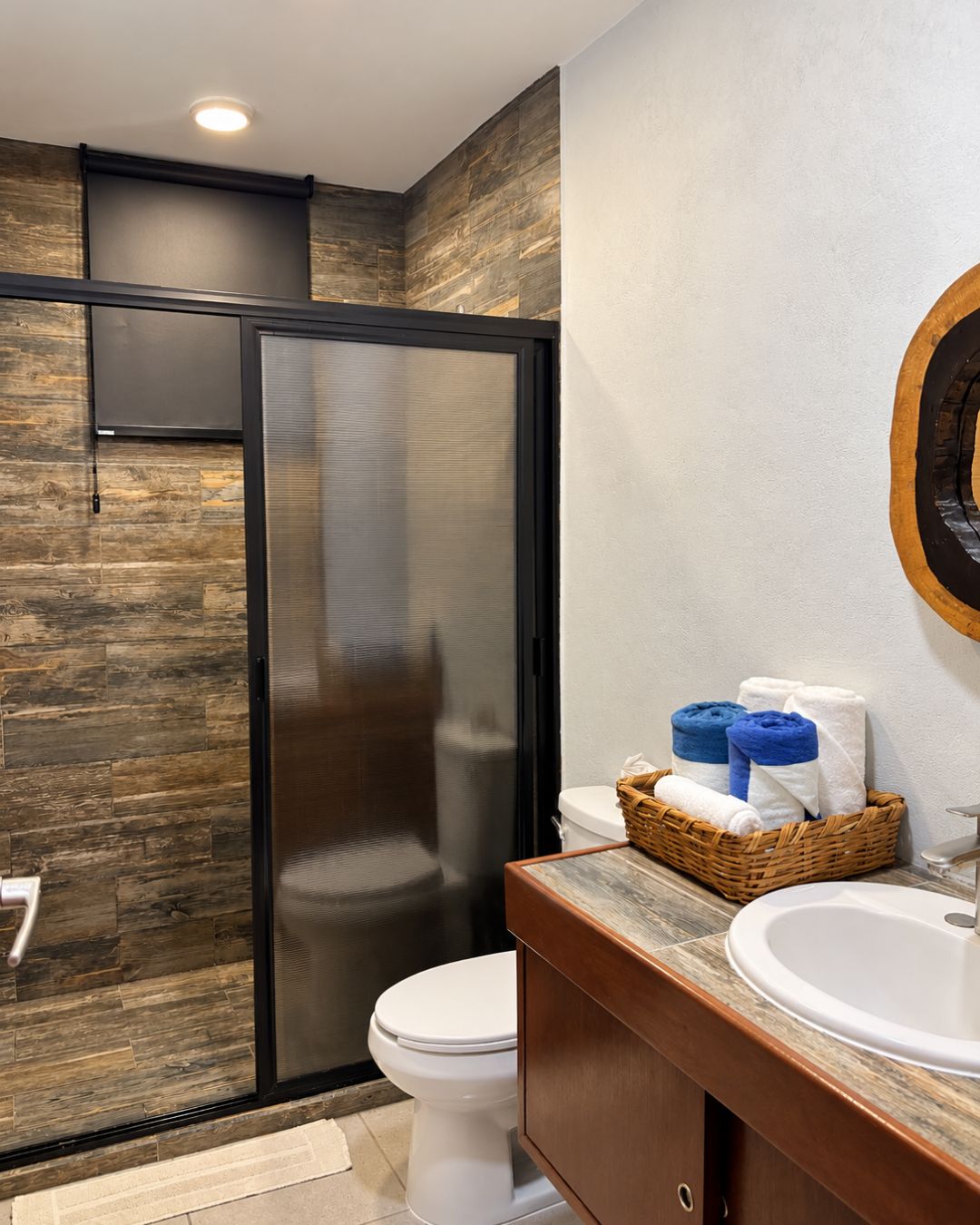 A modern bathroom with a shower, toilet, and sink.