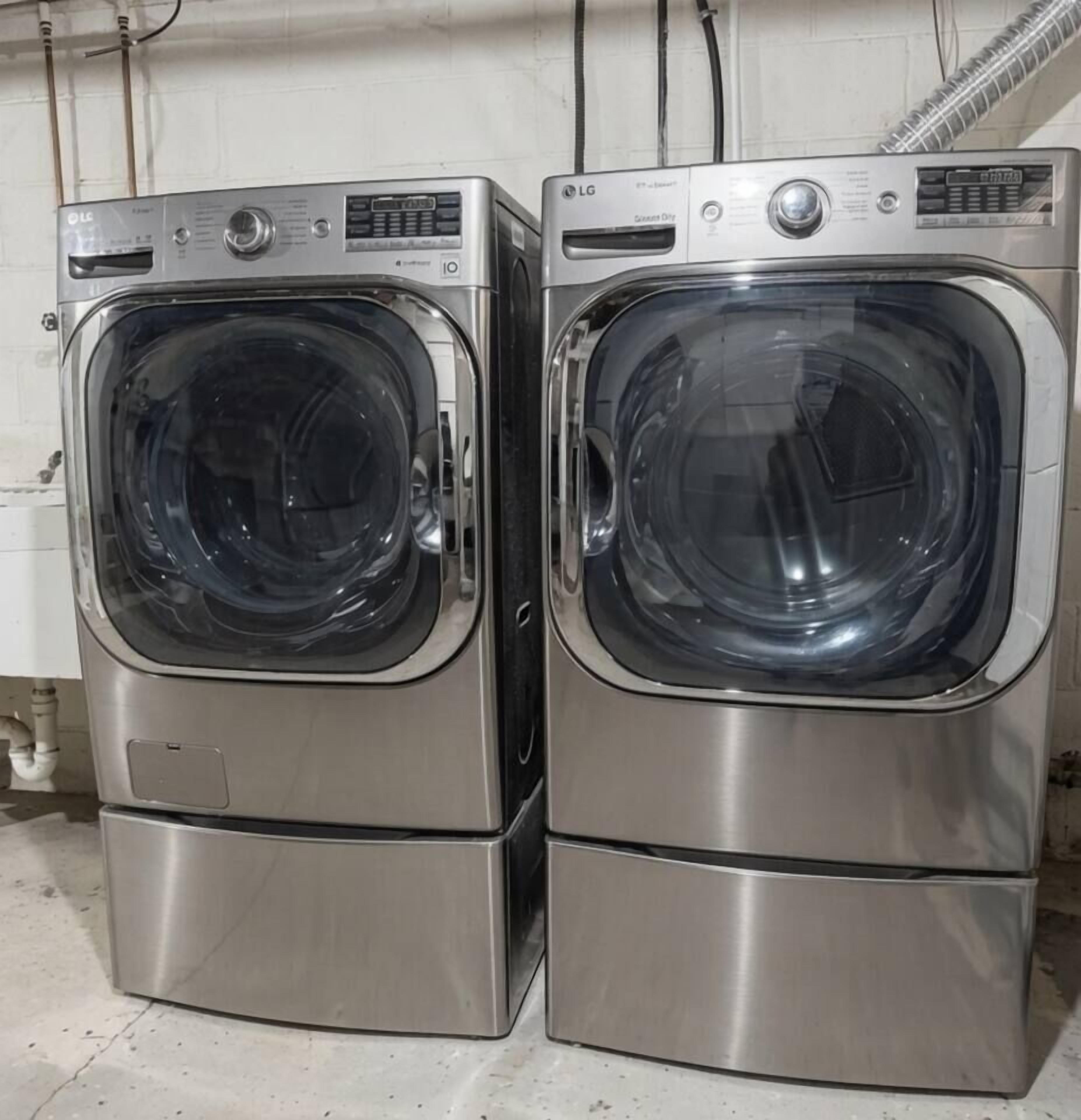Two stainless steel front-loading washing machines in a commercial setting.