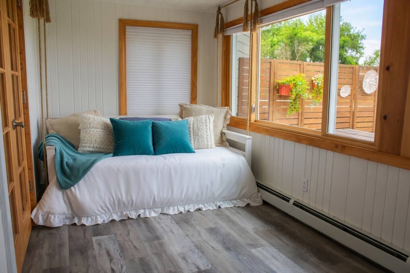 A bedroom with a bed, a window, and a view of the outside.