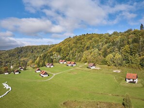 A rural village with traditional houses, a clear sky, and a lush green landscape.
