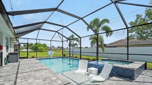 Uma piscina ao ar livre coberta com área de terraço, incluindo espreguiçadeiras e uma banheira de hidromassagem.