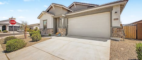 A residential house with a garage, a driveway, and a stop sign.