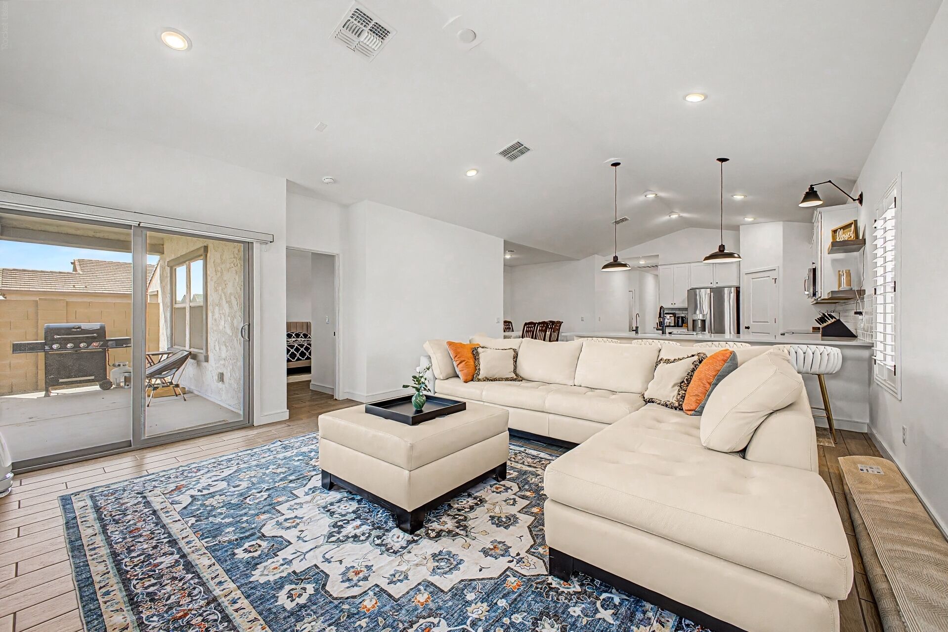 A modern living room with a sectional sofa, a coffee table, and a patterned rug.