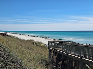 A beach with a wooden walkway leading to the shore, clear skies, and calm sea. - The Coral Palm - Modern, Coastal Boutique Retreat (Inlet Beach)