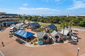 A hotel with a covered outdoor seating area, a small ice cream shop, and solar panels. - The Coral Palm - Modern, Coastal Boutique Retreat (Inlet Beach)