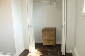 A room with a wooden chest of drawers, white walls, and a tiled floor. - SuiteHart Hideaway: 2 King Beds and 2 Full Baths (Victoria)