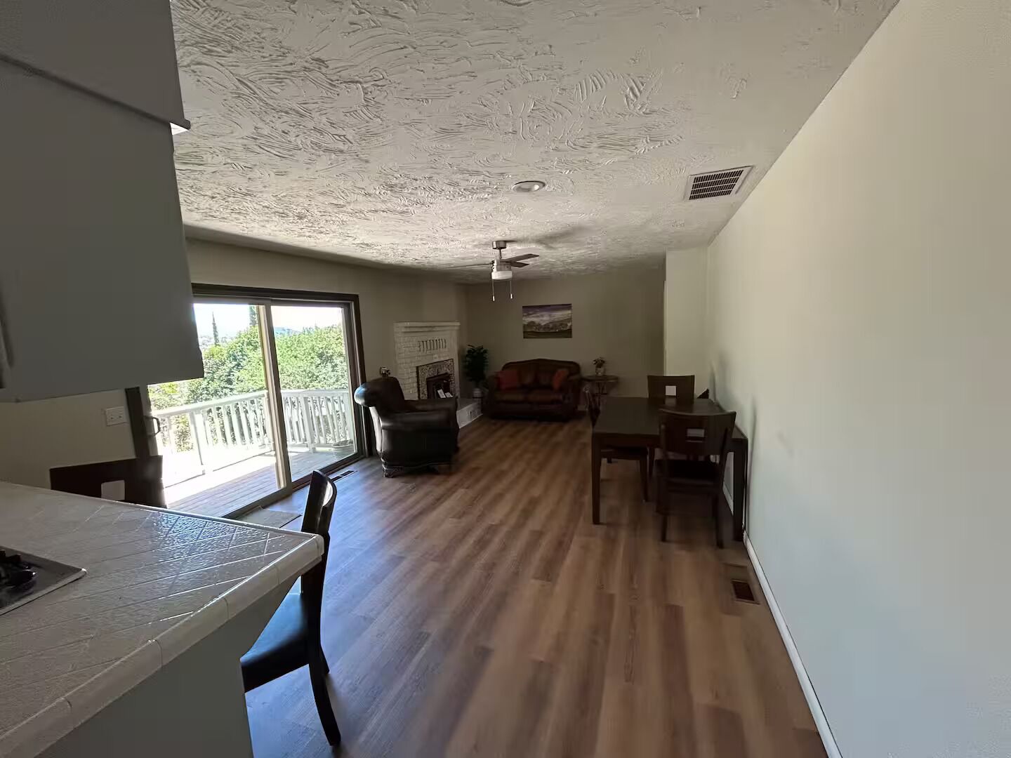 Amplia sala de estar con chimenea, una mesa de comedor y un sofá.