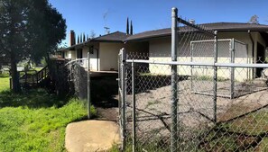 A fenced property with a house, a covered porch, and a clear sky. - - Yosemite Basecamp Lodge - (Mariposa)