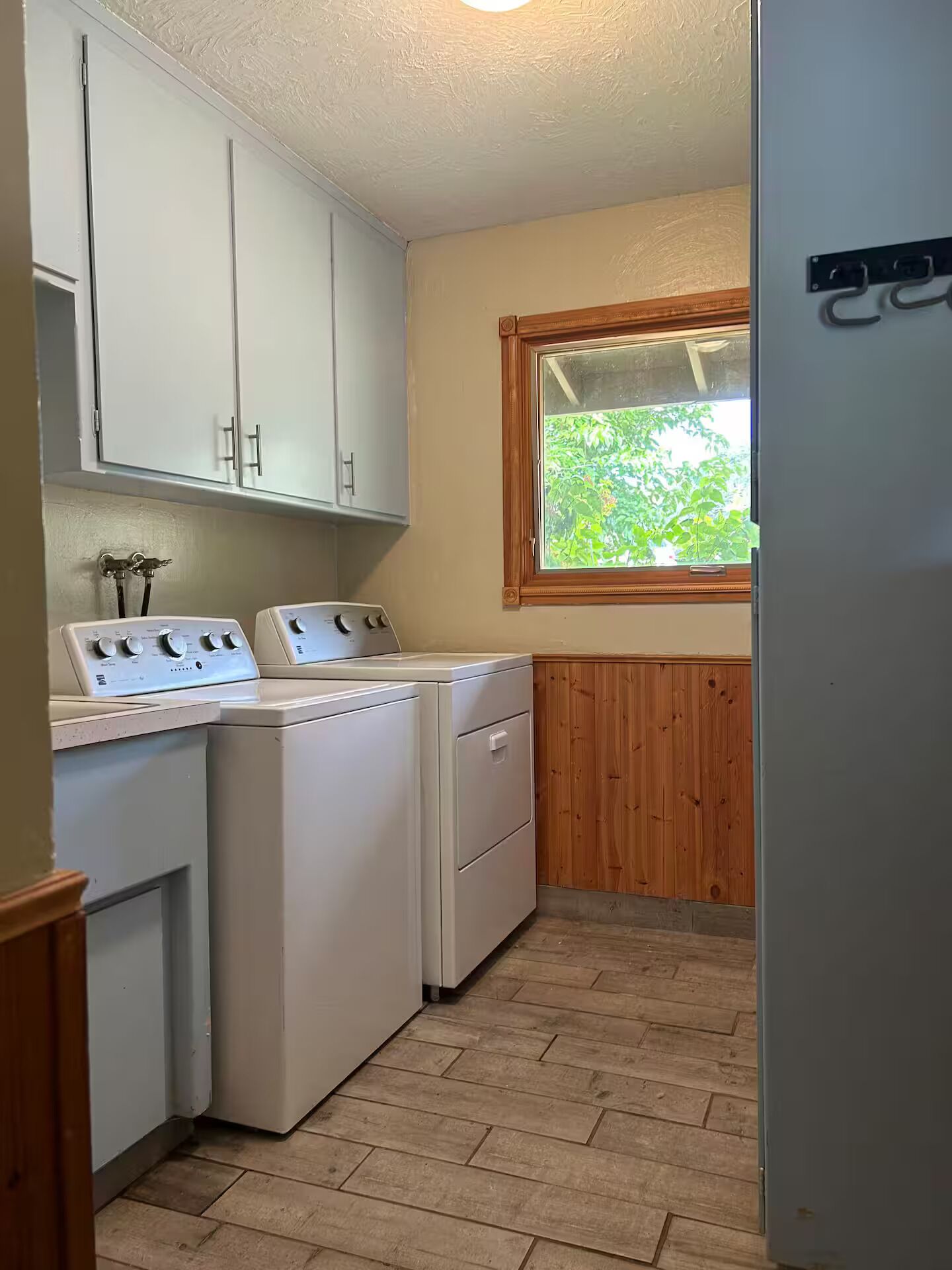 A laundry room with a washing machine, dryer, and cabinets.