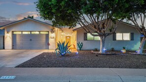 A residential house with a garage, a driveway, and a landscaped front yard with a tree and decorative lights. - Spacious 5-bedroom house fully Furnished Private Pool – Extended Stays Welcome (Scottsdale)