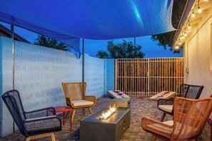 An outdoor patio area with wicker furniture, a fire pit, and a blue canopy. - Spacious 5-bedroom house fully Furnished Private Pool – Extended Stays Welcome (Scottsdale)