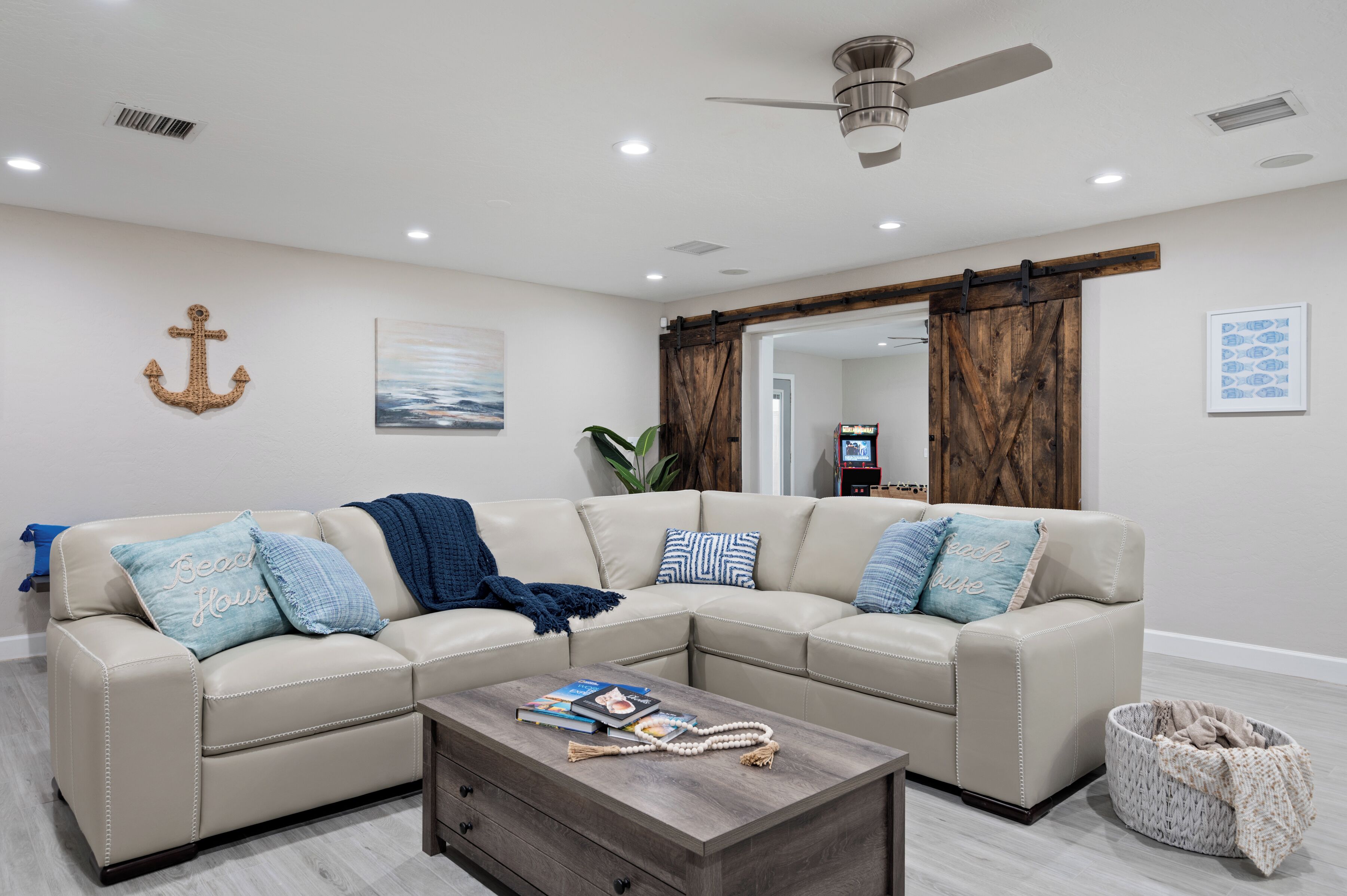 A living room with a sectional sofa, a coffee table, and a ceiling fan.