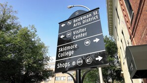 En vägvisningsskylt med pilar som pekar mot Beekman St. Arts District, besökscentret, Skidmore College och butikerna.