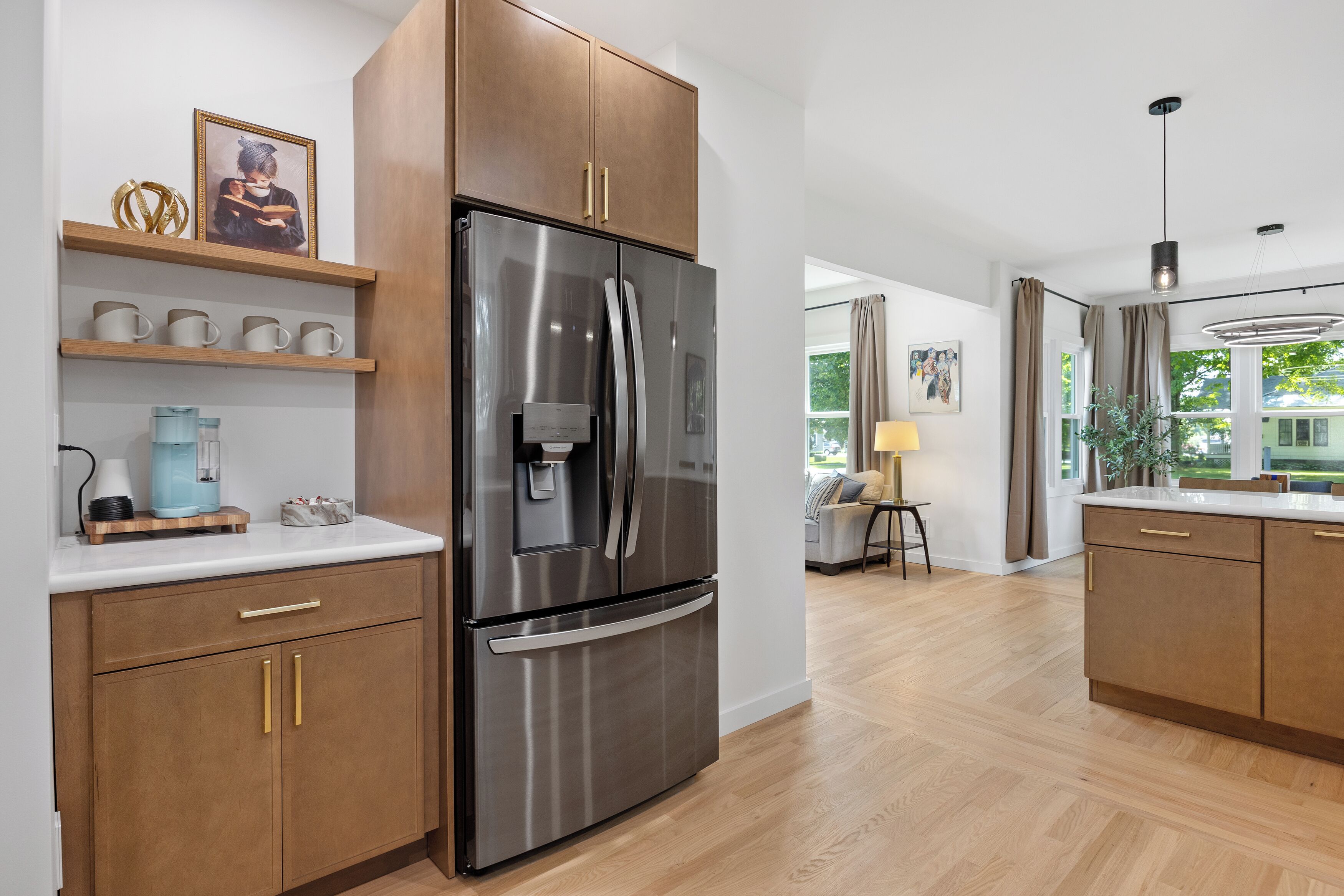 Una cocina moderna con armarios de madera, un refrigerador de acero inoxidable y una cafetera.