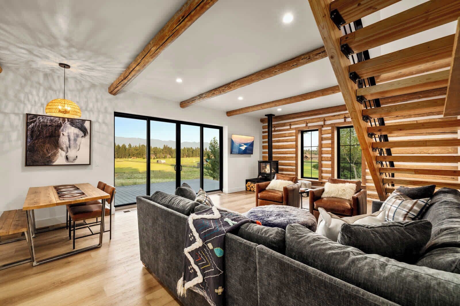 A modern living room with a large sofa, a dining table, and a fireplace.