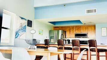 A modern kitchen with wooden cabinets, a microwave, and a coffee maker.