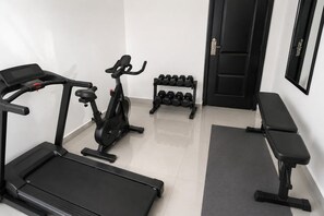 A gym with a treadmill, stationary bike, dumbbells, and a bench. - OceanBlitz at The Vistas-3-bedroom Oceanview House with Pool,Gym,WiFi RunawayBay (Runaway Bay St. Ann)