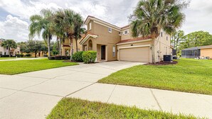 A two-story residential building with a garage, surrounded by well-maintained lawns and palm trees. - 639 - Stylish and newly renovated 6 Bedroom Home 5 Star (Davenport)
