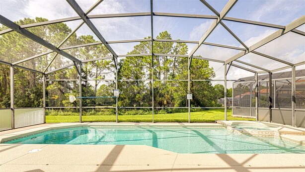 A covered swimming pool with a view of trees and a grassy area. - 639 - Stylish and newly renovated 6 Bedroom Home 5 Star (Davenport)