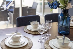 A dining table set with plates, bowls, and wine glasses, with a vase of flowers on the table. - 641 Fabulous 4 bed Villa in Conservation Area with Water View (Davenport)