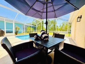 An outdoor patio with a pool, a table, and chairs. - 641 Fabulous 4 bed Villa in Conservation Area with Water View (Davenport)