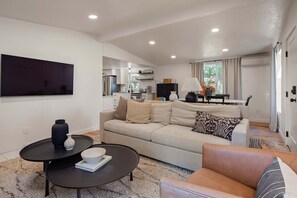 A modern living room with a sofa, coffee table, and a flat-screen TV.