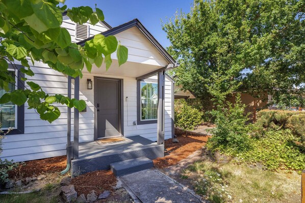 A single-story house with a front porch, a door, and a small window.