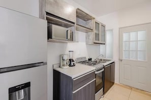 A compact kitchen with a built-in microwave, a coffee maker, a gas stove, and a dishwasher. - Your peaceful retreat in Playa del Carmen (Playa del Carmen)