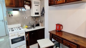 A kitchen with a stove, oven, and wooden cabinets.