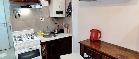 Una cocina con estufa, horno y armarios de madera.